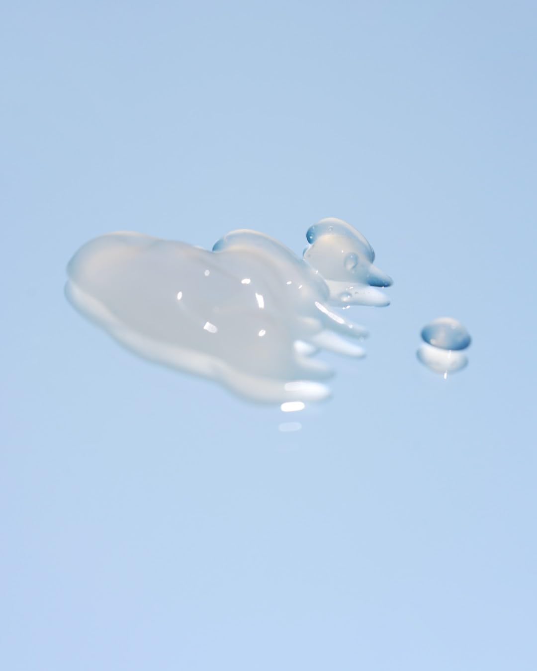 Lightweight blue serum texture applied on skin close up