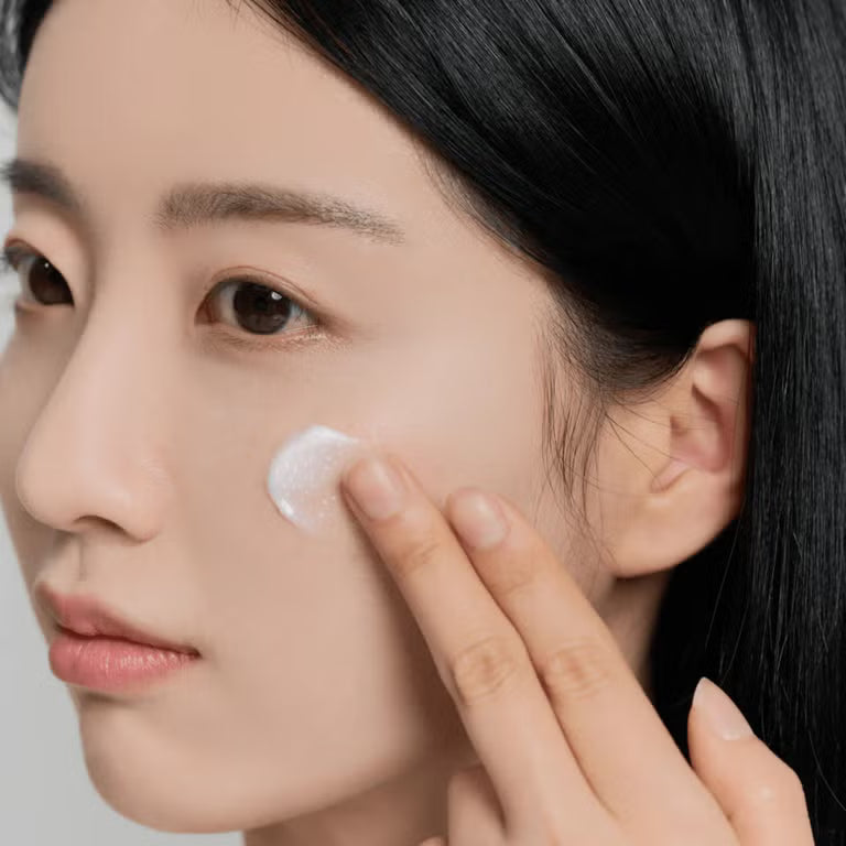 Applying centella brightening cream on face